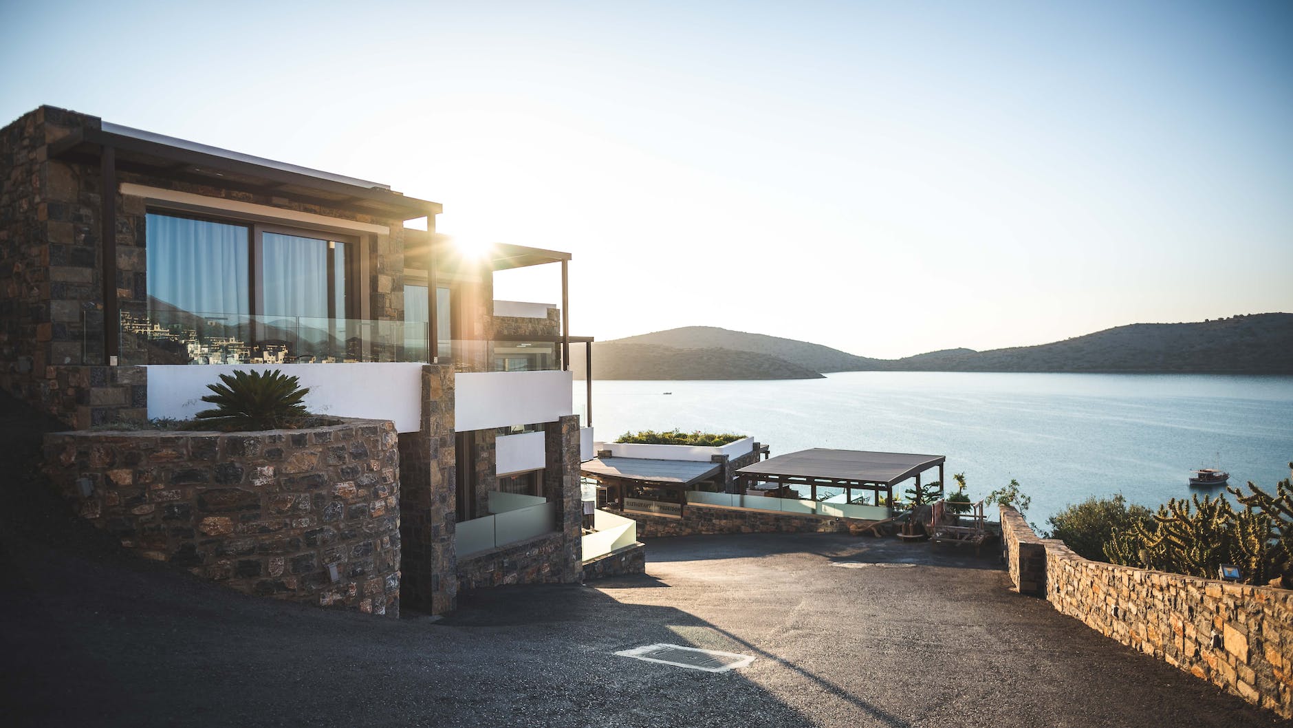 sun piercing of brown concrete house near sea